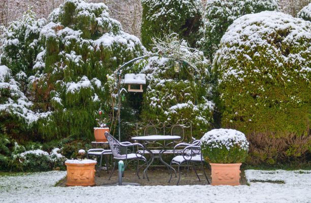 Behavazott kertrészlet madáretetővel és kerti bútorral
